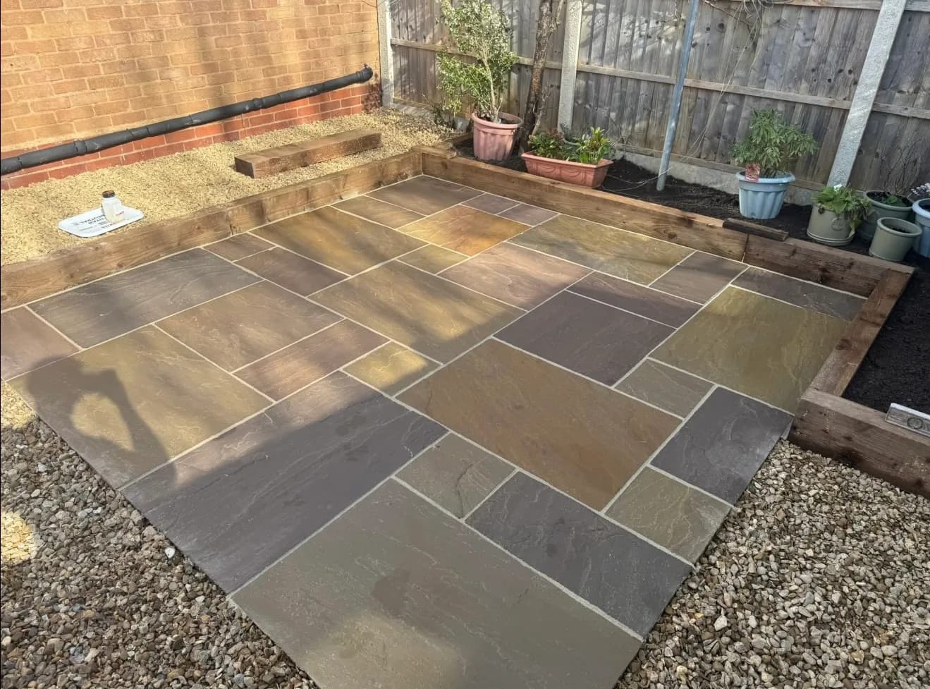 Indian sandstone patio laid in a back garden by Akromis