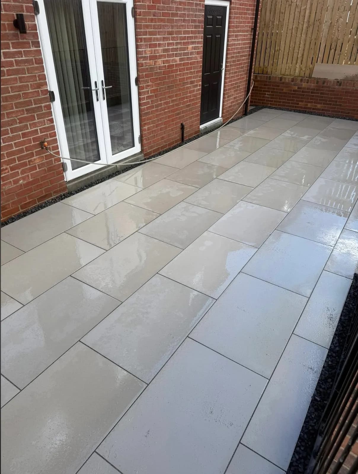 Light porcelain-paved patio outside patio doors, laid by Akromis